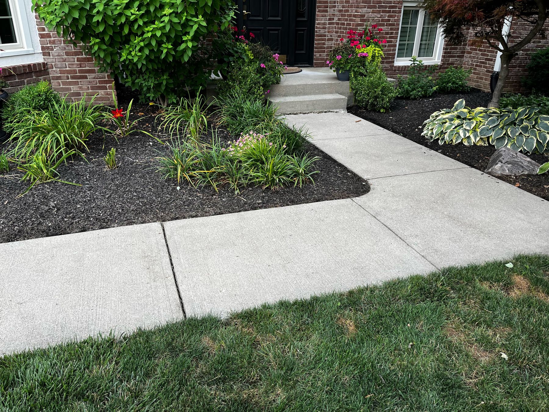 Freshly pressure-washed driveway in front of a brick house